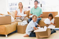 Photograph of happy family unpacking boxes